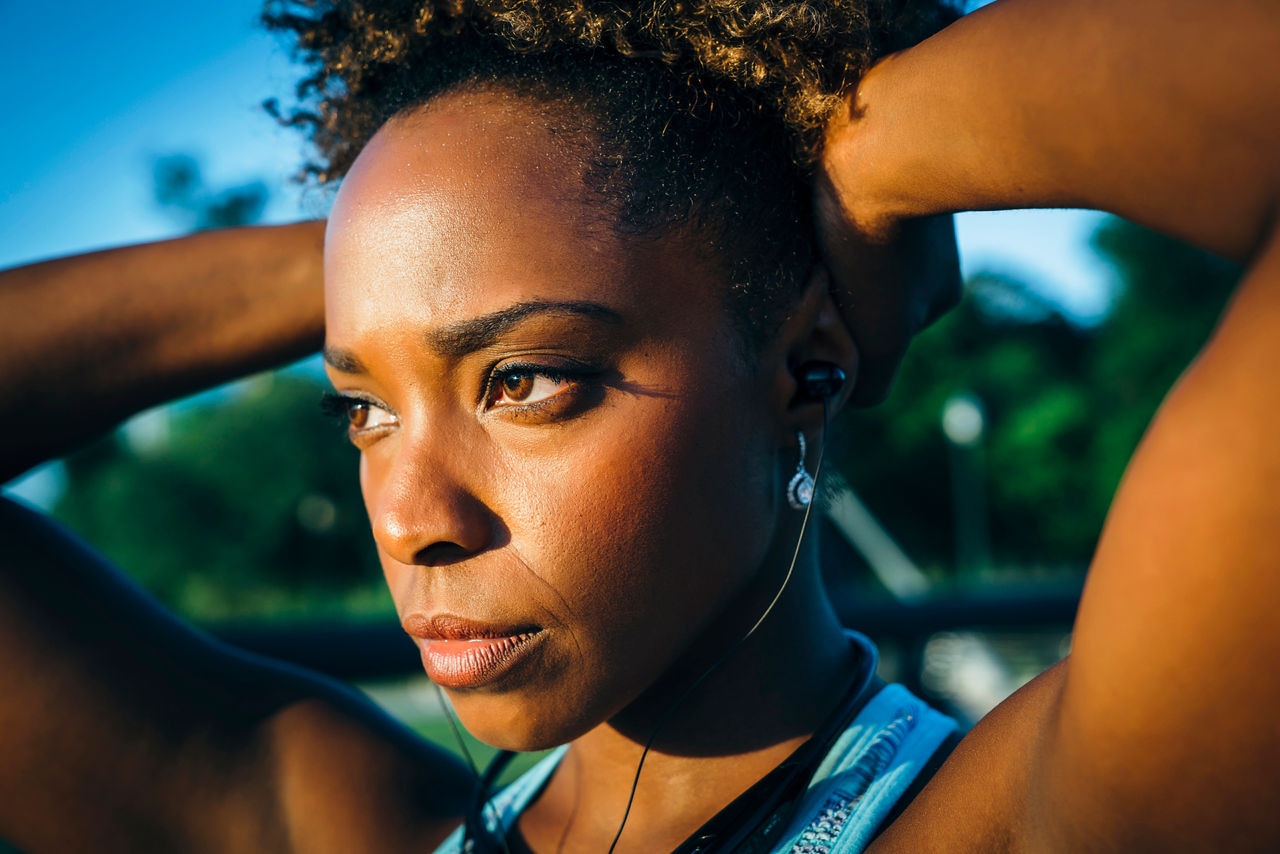 Close up of serious mixed race woman listening to earbuds
