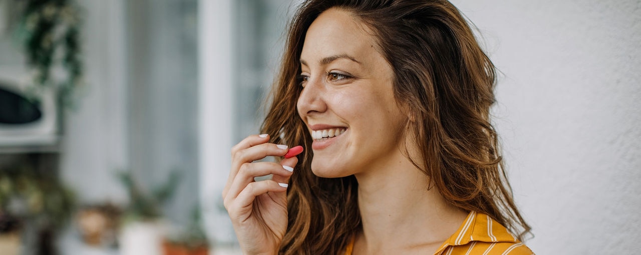 Young adult takes supplements at home