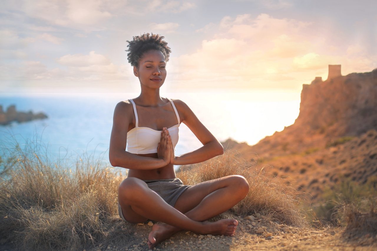 Pretty girl relaxing and meditating in a wonderful natural place
