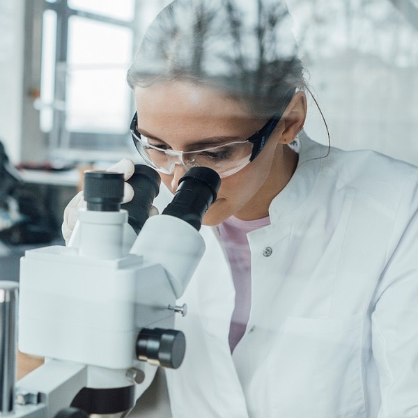 Young scientist working on microscope in laboratory