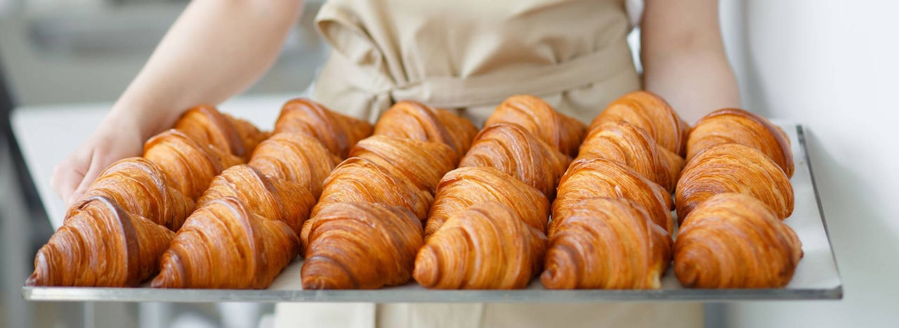 banner-baker-carrying-freshly-baked-crispy-golden-croissants(2).jpg